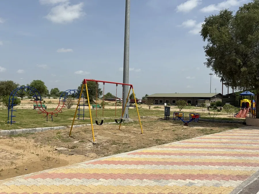Swings and a walking path in the Guru Kripa garden, Agolai